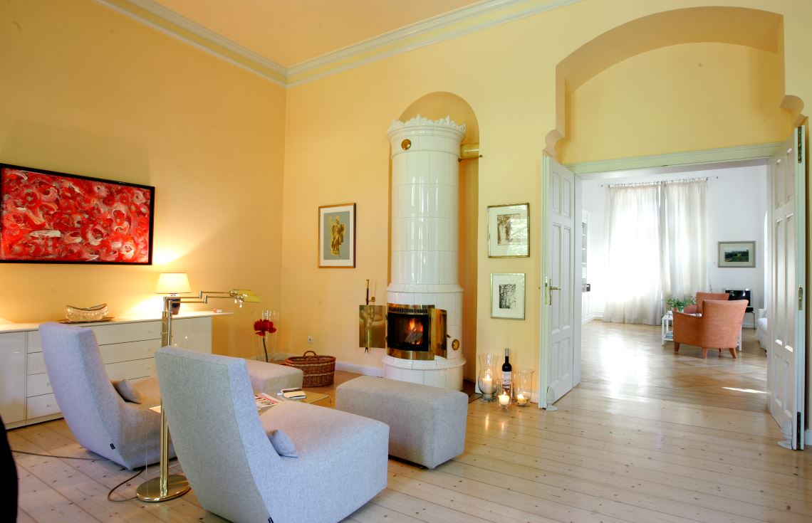 Poêle en faïence suédoise Sonya devant un mur jaune